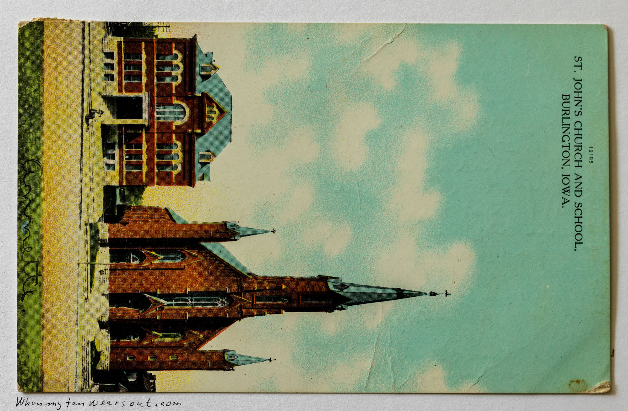 Vintage postcard featuring an upside-down view of St. John's Church, a tall brick building with spires, next to a matching brick school building under a light blue sky with white clouds. Text at the bottom reads