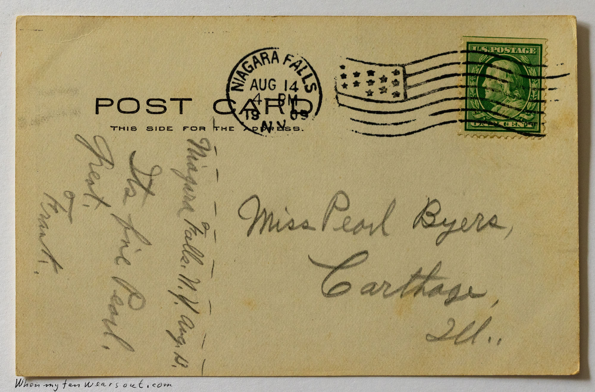 The back of a vintage postcard featuring a divided back for message and address. Handwriting in cursive reads