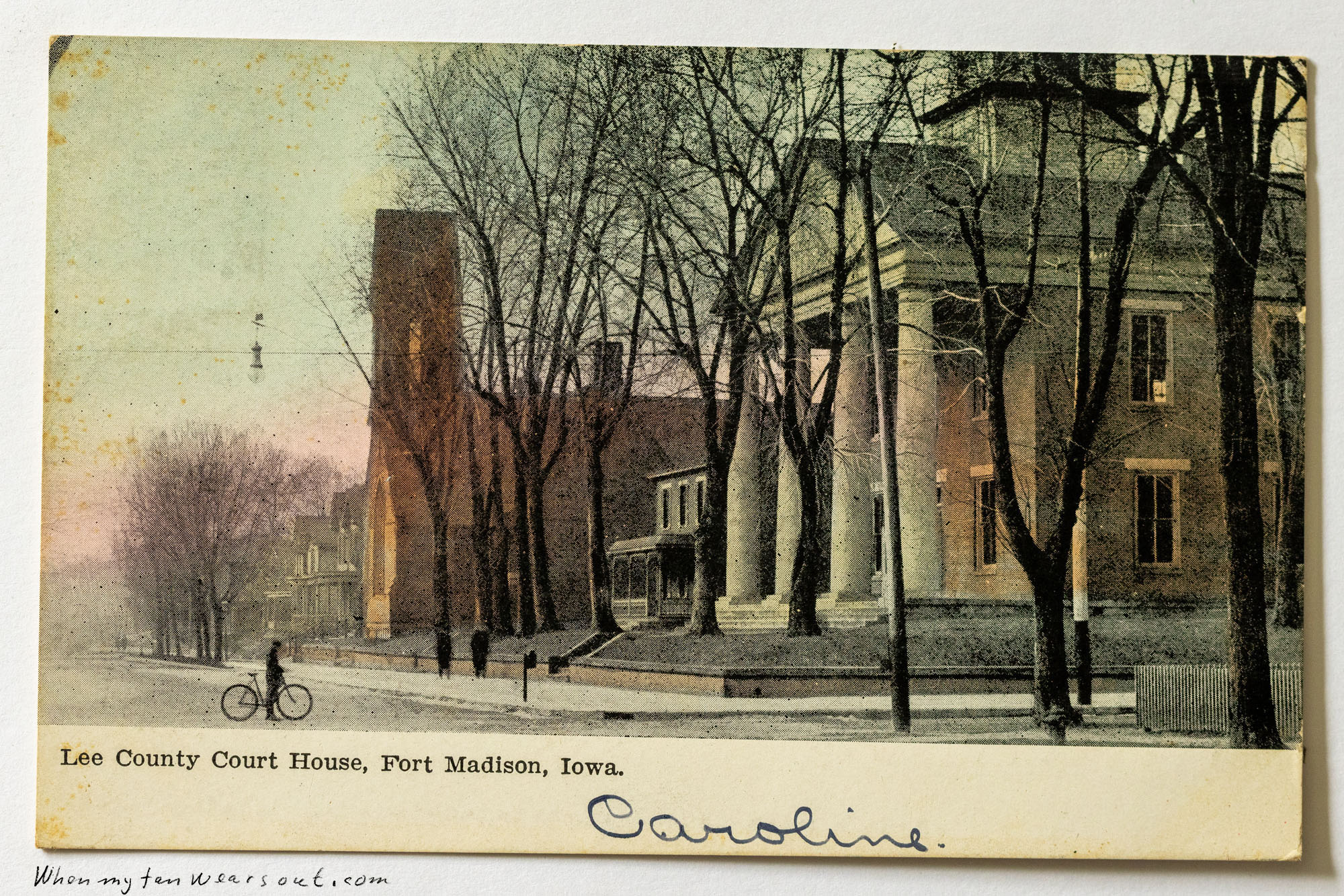 Front of postcard #0077: Colorized postcard depicting the Lee County Court House in Fort Madison, Iowa, featuring its prominent white columns. Ba