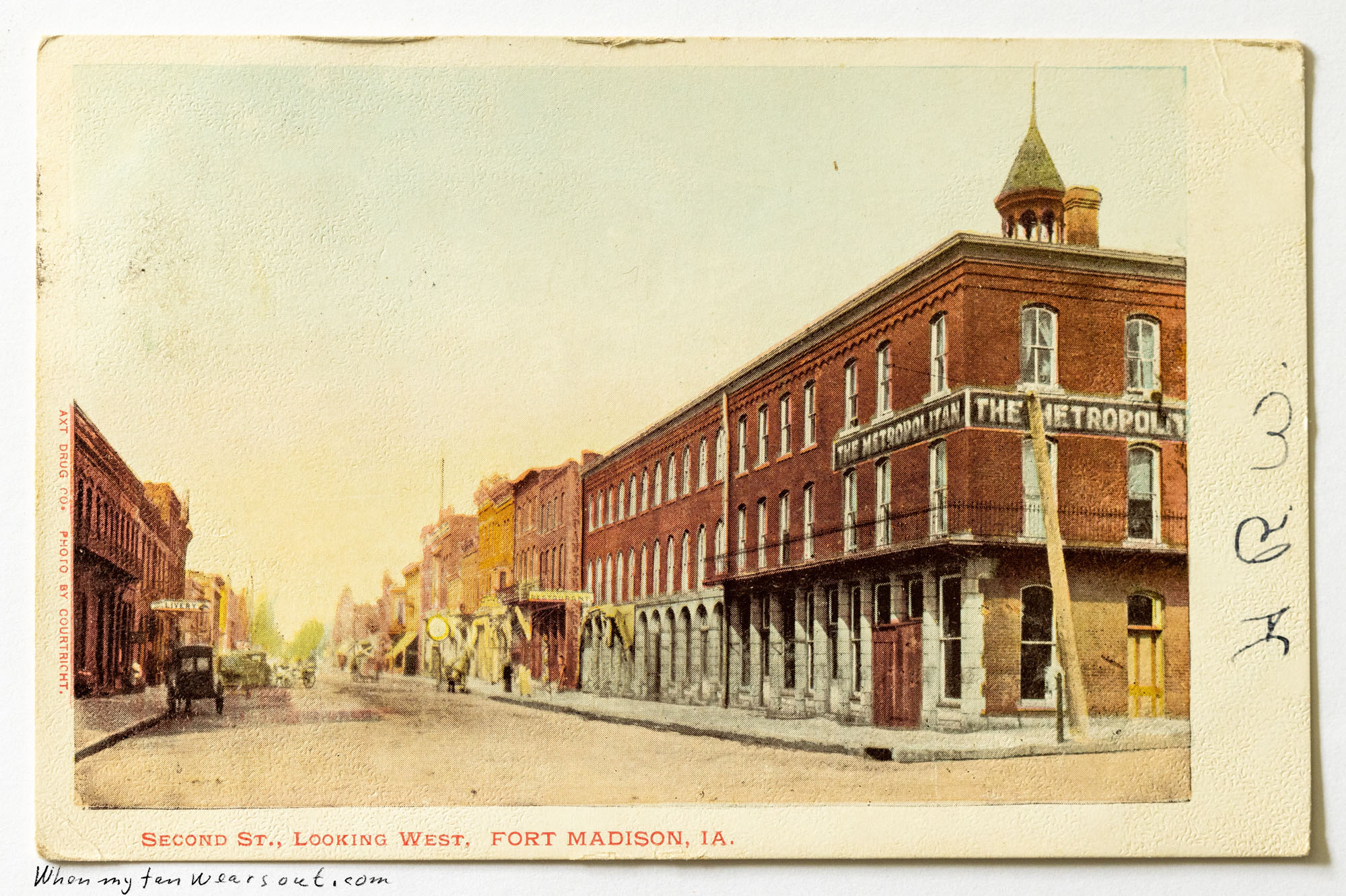 Front of postcard #0091: Color postcard depicting a street scene of Second Street looking west in Fort Madison, Iowa. On the right side of the st