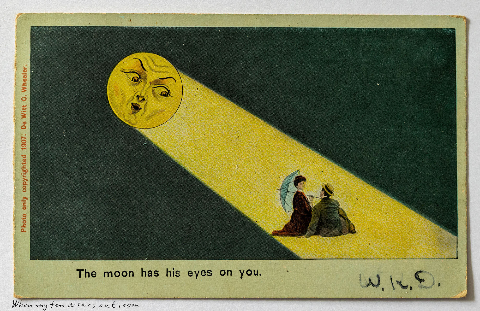 Front of postcard #0092: Illustration of a large yellow man-in-the-moon shining a beam of light onto a couple sitting together on the ground. The