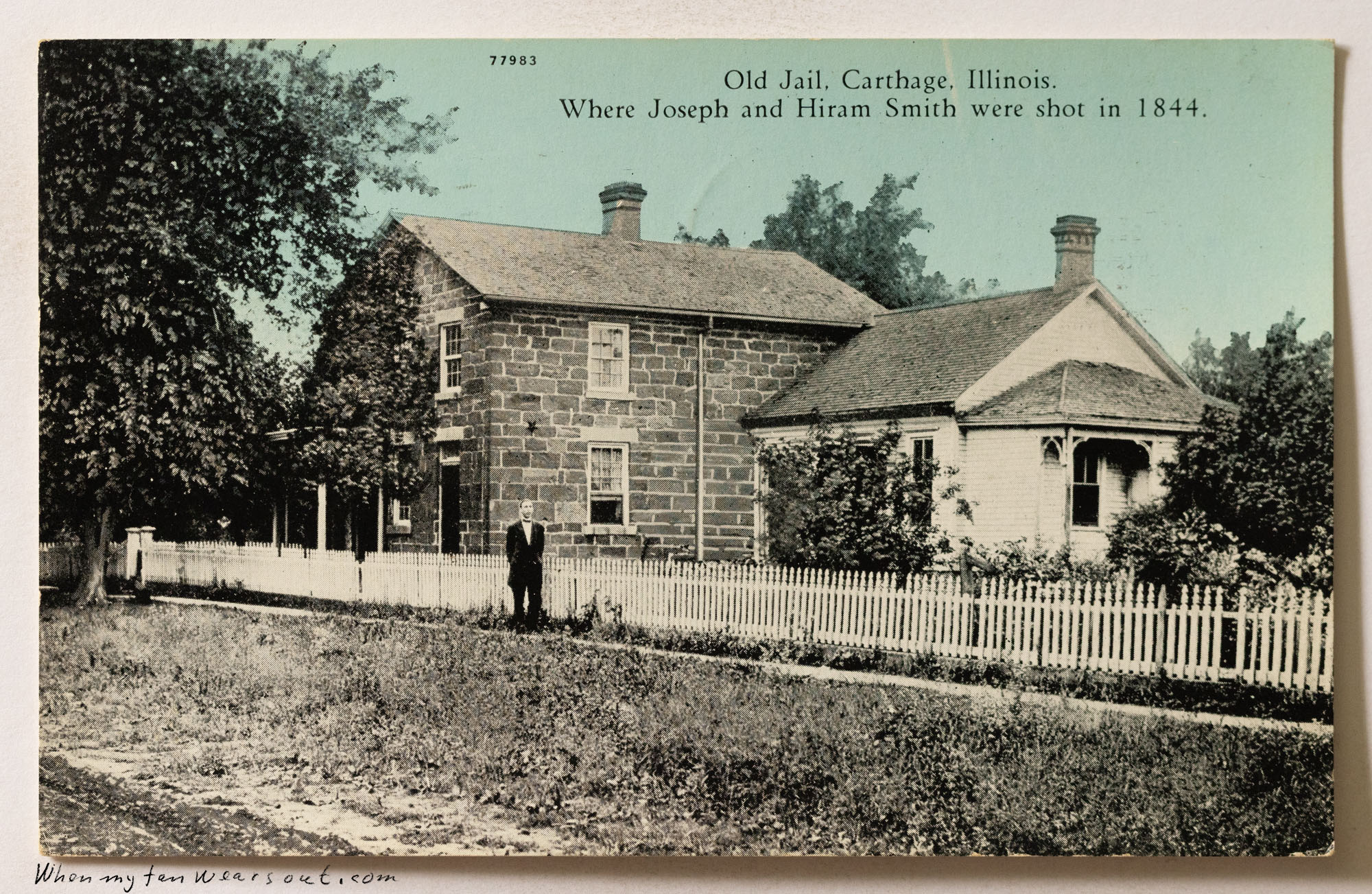 Front of postcard #1088: Hand-colored postcard showing the "Old Jail" in Carthage, Illinois. The scene features a two-story stone building with a
